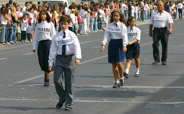 Eine Gruppe von Menschen auf der Straße, die Abzeichen auf ihren Hemden tragen, mit einer großen Menge, die sich um die Straße sammelt.