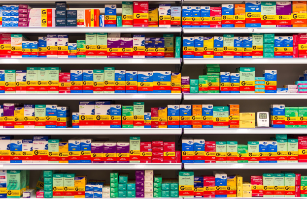 Ordentlich sortierte Apothekenregal mit verschiedenen Medikamentenschachteln.