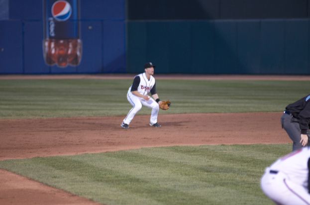 Personen auf Gras mit einem kalten Getränkeplakat und Text im Hintergrund.