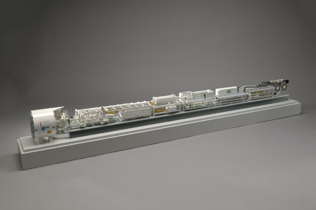 Ein detailliertes Modell eines Sainsbury's Wasserstoff-Brennstoffzellensystems, das miteinander verbundene Komponenten wie einen Kraftstofftank, ein Filter und eine Einspritzdüse auf einer weißen Oberfläche zeigt.