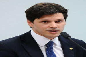 Ein Mann im Anzug spricht in ein Mikrofon und scheint die Nachricht von einem vom Staat genehmigten Gesetz zu verkünden, das den Internetgebrauch verbietet.