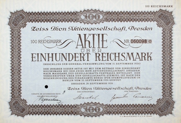 Ein altes deutsches Aktienzertifikat mit schwarzem Rand und der Inschrift "Aktie über Einhundert Reichmark".