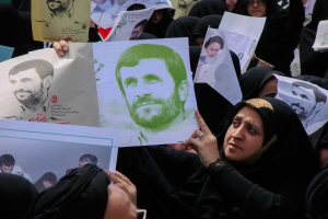 Eine Gruppe iranischer Frauen in schwarzer Kleidung, einige mit Brille, halten Fotos des Präsidenten Mahmoud Ahmadinejad während einer Kundgebung in Tehran hoch.