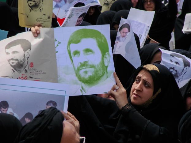 Eine Gruppe iranischer Frauen in schwarzer Kleidung, einige mit Brille, halten Fotos des Präsidenten Mahmoud Ahmadinejad während einer Kundgebung in Tehran hoch.