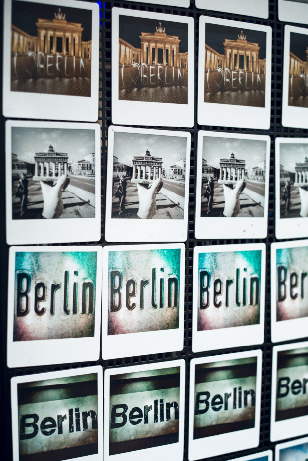 Collage aus Berlin-Fotos einschließlich des Brandenburg-Tors und dem Wort 'Berlin' auf einer Wand.