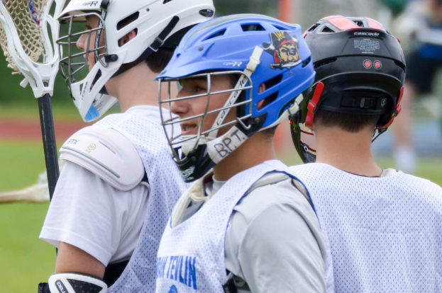 Drei Spieler in weißen Jacken und Helmen, mit einem unscharfen Hintergrund.