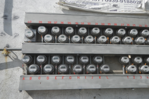 Nahaufnahme eines Elektrizitätszählers an der Seite eines Gebäudes mit einer Banneranzeige oben.