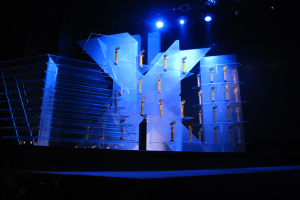 Bühne für eine Preisverleihung mit dunklem Hintergrund und minimaler Beleuchtung, die ein paar Gegenstände auf der Bühne enthält.