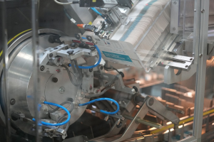 Automatisiertes Verpackungssystem-Maschine auf einem Fabriktisch mit unscharfen Hintergrundobjekten.