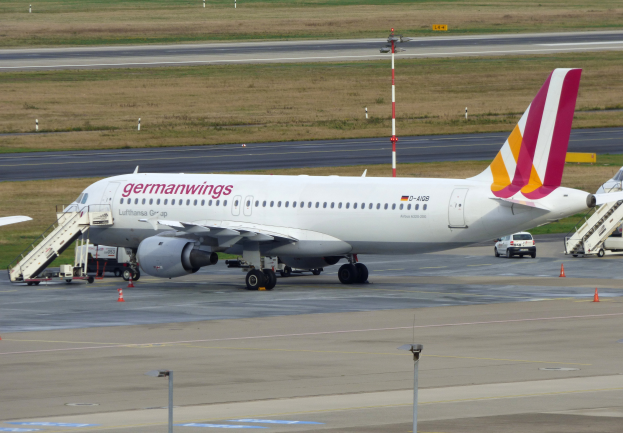 Ein Airbus A320-200 der Germanwings auf dem Frankfurter Airport, mit Fahrzeugen, Verkehrskegeln, Pfählen und Gras im Hintergrund.