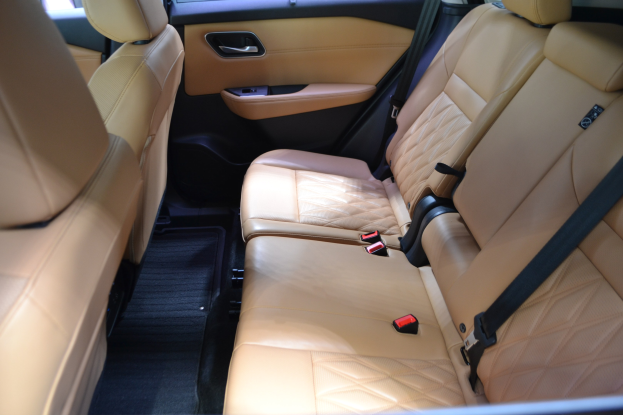 Innenraum eines Autos mit braunem Leder-Sitzen, Sicherheitsgurten, Türen, Fenstern und anderen Gegenständen in luxuriösem und stilvollem Design.