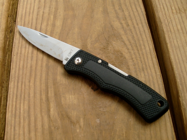 Ein Messer liegt auf einer braunen Oberfläche.