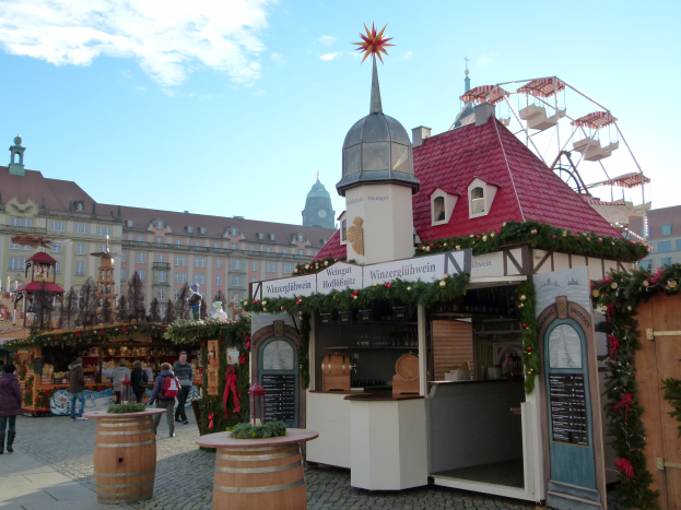 Ein lebendiger Weihnachtsmarkt in Nürnberg, Deutschland, mit Menschen um geschmückten Ständen, Gebäuden, einem Riesenrad und einem bewölkten Himmel, mit einer Tafel auf der rechten Seite.