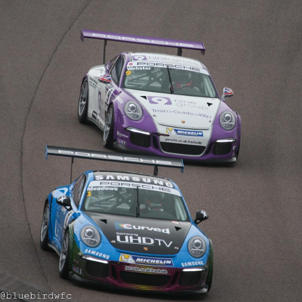 Zwei Autos auf einer Straße außerhalb der Stadt mit Text in der linken unteren Ecke.