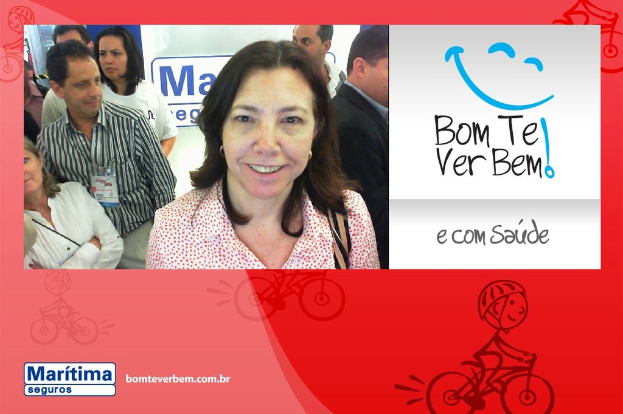 Eine Frau, die im Vordergrund lächelt, mit Menschen im Hintergrund, Text und ein Cartoon-Emoji oben rechts und eine Cartoon-Person, die unten fährt.