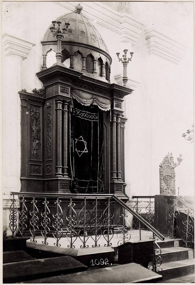 Schwarze und weiße Fotografie einer jüdischen Synagoge in New York City mit Treppe, Geländer, Säulen, Tür und Wand.
