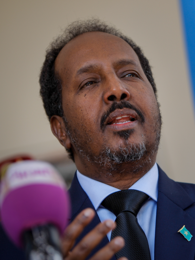 Ein Mann im Anzug und Krawatte spricht in ein Mikrofon, wahrscheinlich zu einem Publikum als Politologe.