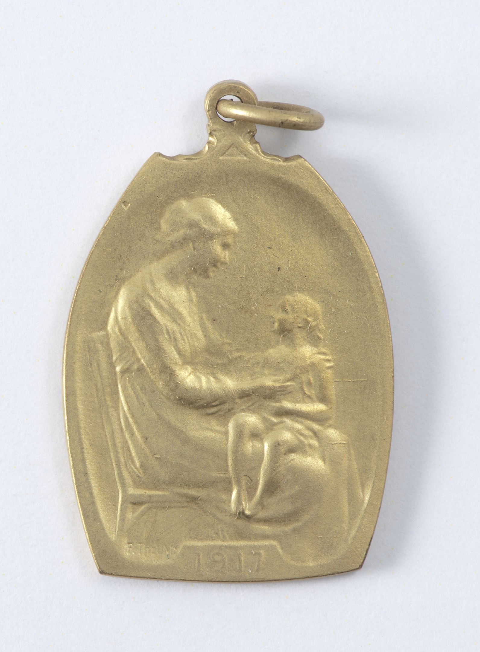 Goldmedaille mit einer Reliefdarstellung einer Frau in einem weißen Kleid mit einem Knoten im Haar, die ein Kind hält, mit der Inschrift "Mutter und Kind."