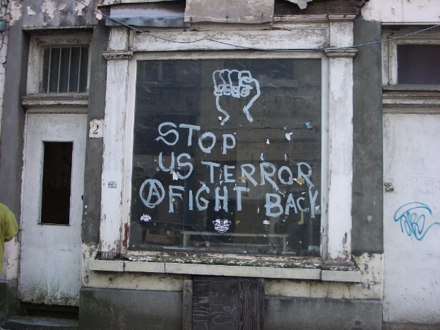 Ein Gebäude mit mehreren Fenstern und einer Glastür mit Text.