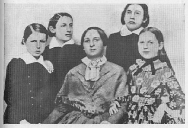 Schwarzes und weißes Foto einer vielfältigen Gruppe von Frauen aus der Frauenwahlrechtsbewegung, mit einer Frau in der Mitte sitzend.