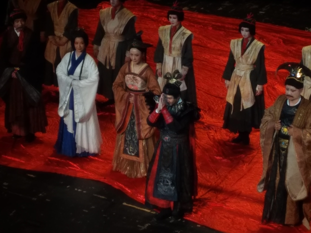 Eine Gruppe von Menschen auf einem roten Teppich, einige in Kostümen.