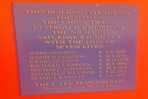 Plaque an einem Gebäude, das den Ort des Geisterzugbrandes am 9. Juni 1979 erinnert, bei dem sieben Menschen starben.