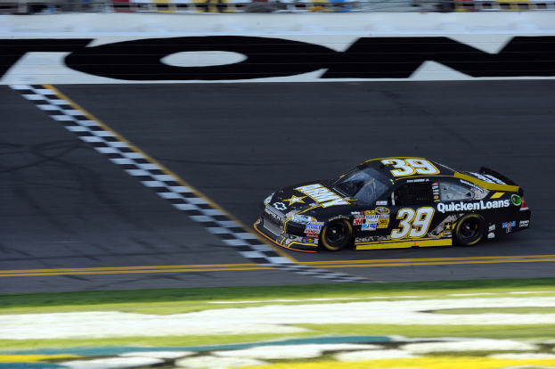 Ein Rennwagen auf einer Straße mit Gras am Boden und Text auf dem Auto.