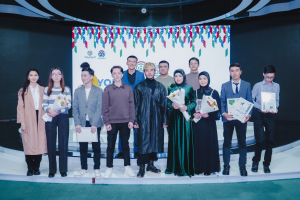 Gruppe von Menschen auf einer Bühne mit Blumensträußen und Urkunden vor einem "Jugend-Solar-Awards 2019"-Hintergrund.