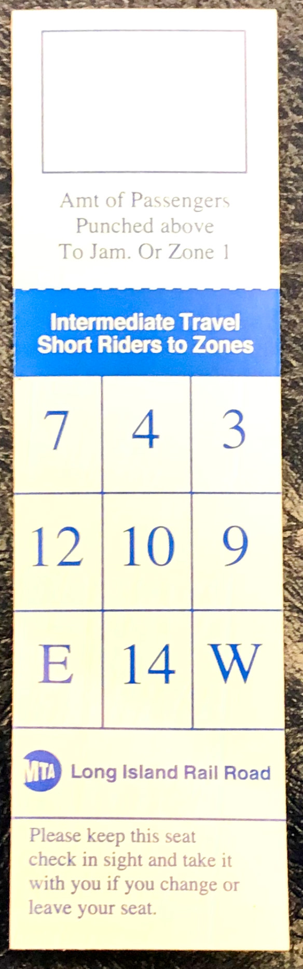 Ein blau-weißes Ticket mit aufgedrucktem Text und Zahlen liegt auf einem Tisch.