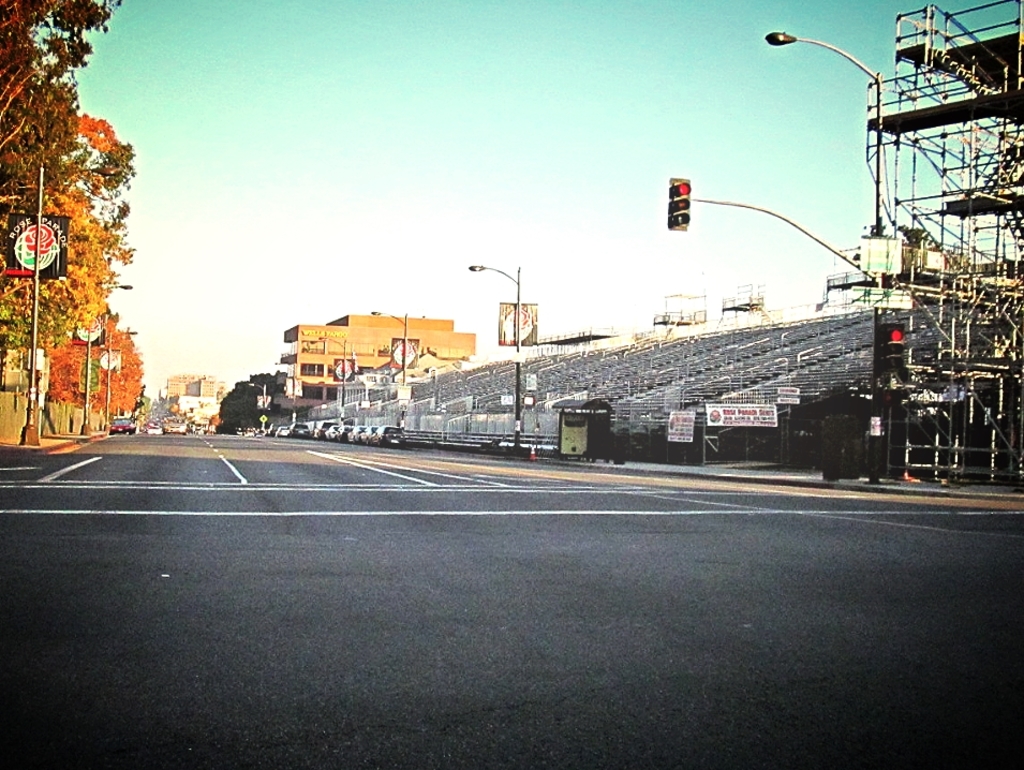 Eine Straße mit einem Verkehrssignalmast und Equipment auf der rechten Seite, Warnschilder und mehrere Fahrzeuge auf der linken Seite sowie Bäume im Hintergrund.