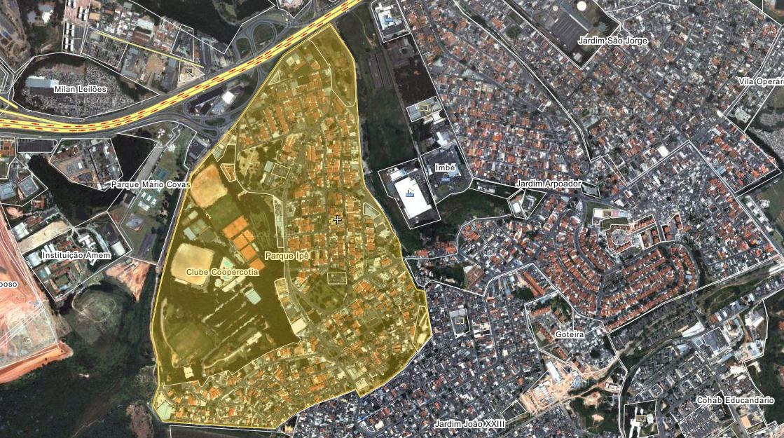 Luftaufnahme einer Stadt mit Gebäuden, Straßen, Bäumen und Gras, mit einer zentralen Karte eines geplanten Entwicklungsstandorts.